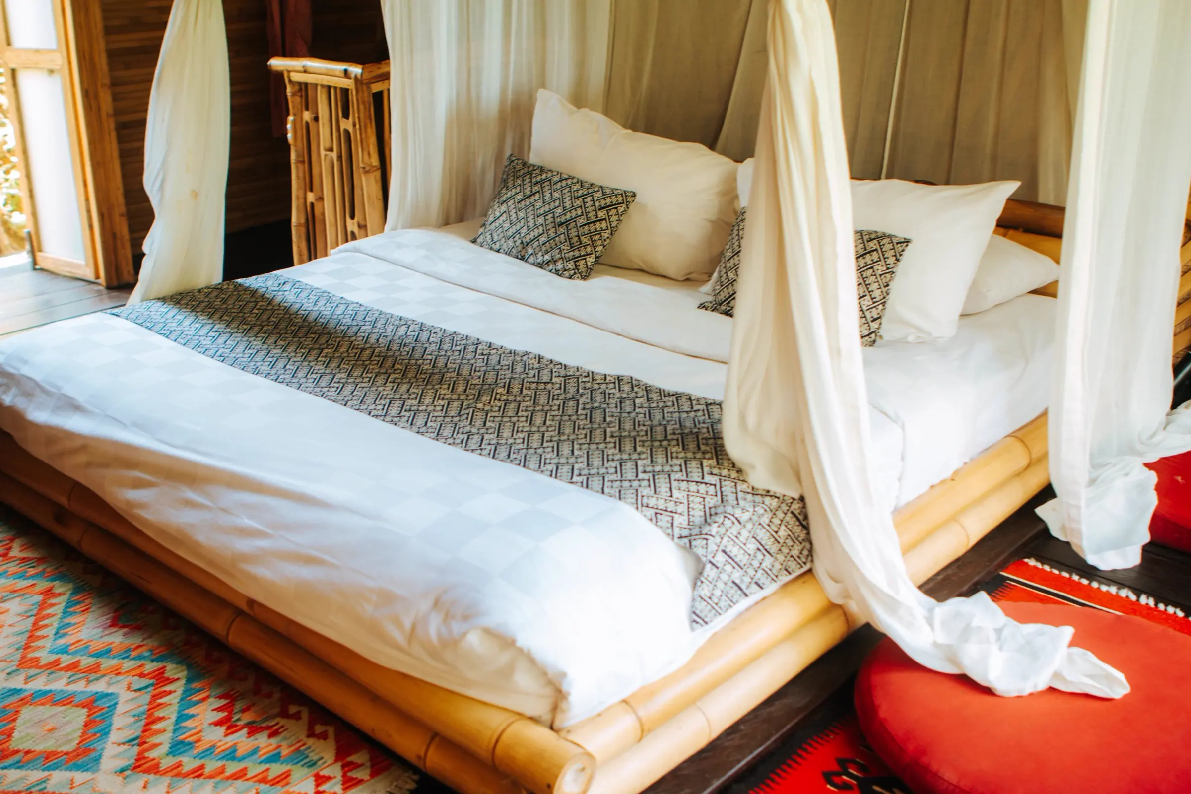 A bed under a mosquito net in one of the houses
